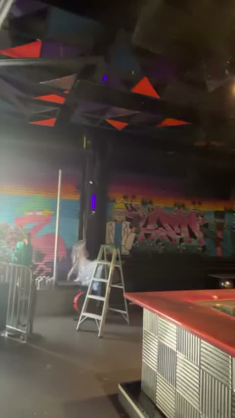 The rainbow graffiti mural wall mid-build, under triangle ceiling panels